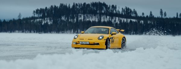 Ein Porsche Sportwagen fährt schnell im Schnee.